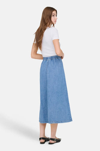 T-shirt blanc à manches courtes ONLY, associé à une jupe midi en jean et des chaussures plates noires.