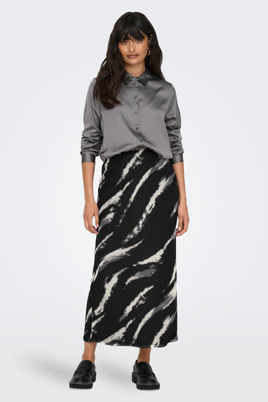 Jupe grise d'ONLY, avec un motif à rayures noires et blanches, associée à une blouse de soie grise et des chaussures noires.