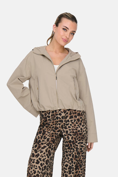 Manteau beige de ONLY®, avec des manches longues, une fermeture éclair et un imprimé léopard sur le pantalon.