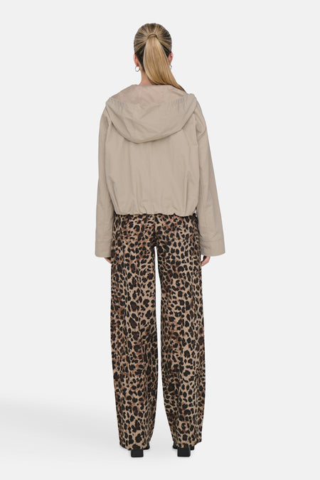 Manteau court beige ONLY, avec des manches longues et un capuchon, associé à un pantalon imprimé léopard.