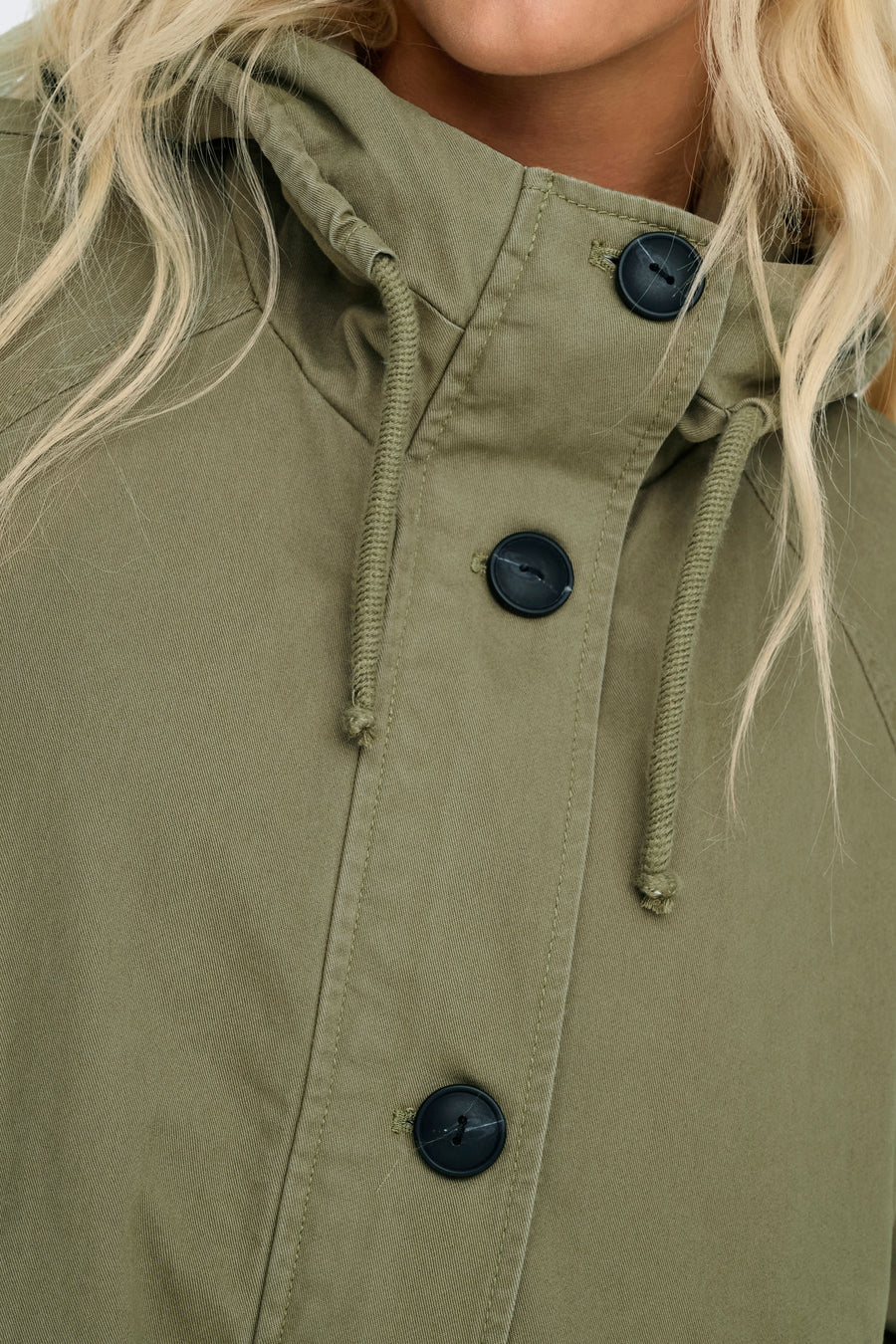 Groene jas met knopen en capuchon.