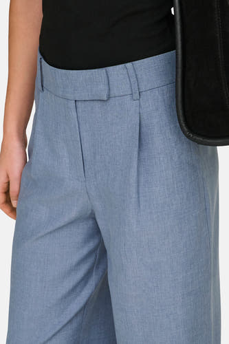 Pantalon de costume bleu ONLY®, avec plis et une partie d'une sac noir visible.