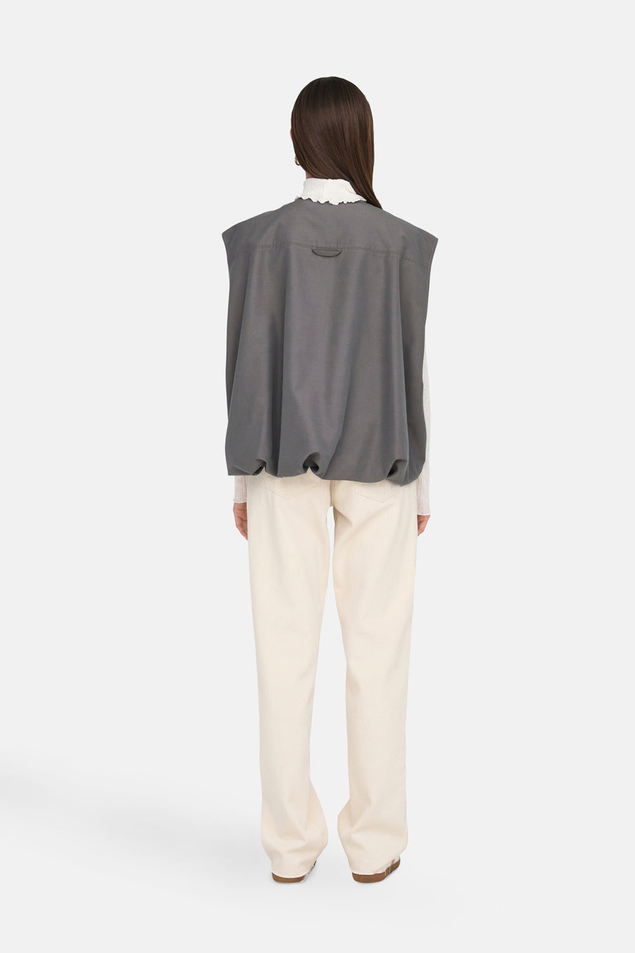 Gilet gris ONLY, avec une coupe décontractée et un short beige visible et un haut blanc.
