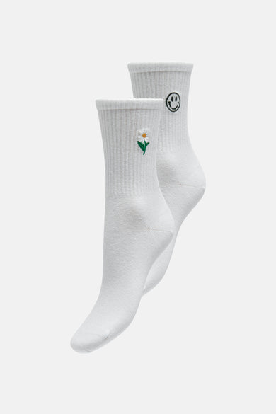 Chaussettes blanches d'ONLY, avec une fleur brodée sur l'une et un smiley sur l'autre chaussette.