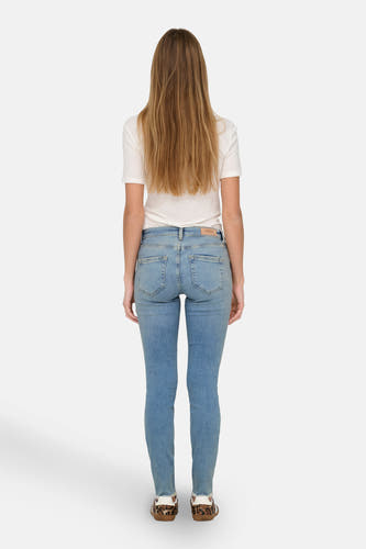 Jean skinny bleu clair d'ONLY, avec étiquette de marque visible et associé à une chemise blanche.
