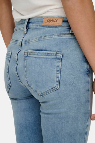 Jean skinny bleu clair ONLY, avec des poches arrière et une étiquette en cuir de marque sur la ceinture.