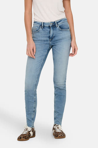 Jean skinny bleu clair d'ONLY, avec des détails détruits et associé à des baskets au motif de léopard brun-blanc.