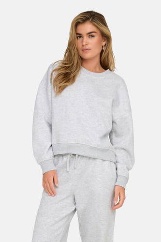 Pull-over gris avec col rond de ONLY, porté avec un short de jogging gris et des baskets.