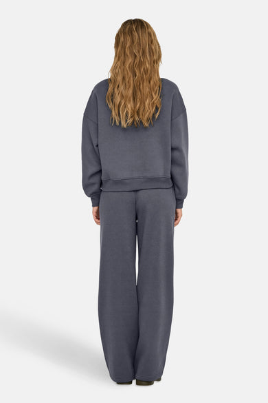 Pull-over bleu d'ONLY®, avec des manches longues et un col rond, vu de dos.
