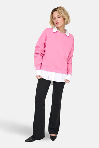 Roze sweater van ONLY, gedragen over een wit overhemd en gecombineerd met zwarte broek.
