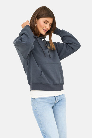 Pull-over bleu avec capuche ONLY, avec cordon de serrage, poche kangourou et associé à un T-shirt blanc et des jeans.