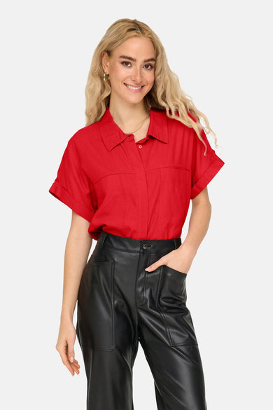 T-shirt rouge à manches courtes de ONLY, avec poches devant et porté avec un pantalon noir.