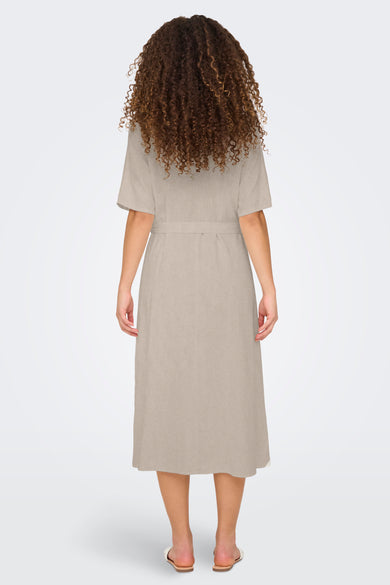 Manteau beige à manches courtes de JDY, vu de derrière, avec une ceinture et des cheveux bouclés.