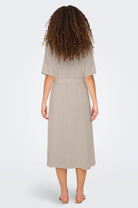 Manteau beige à manches courtes de JDY, vu de derrière, avec une ceinture et des cheveux bouclés.