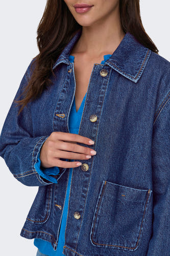 Veste en jeans bleu marine de ONLY®, avec fermeture à boutons et poches, portée sur un haut bleu.