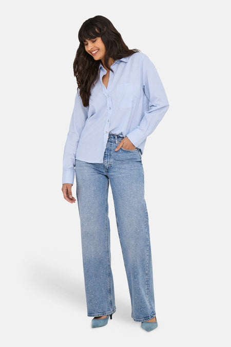 Blauw hemd van ONLY, met lange mouwen en een borstzak, gecombineerd met wijde jeans en hakken.