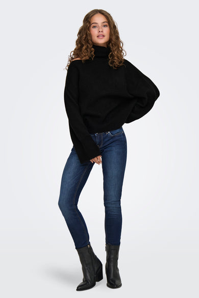 Pull à col roulé noir de JDY, modèle ample avec structure côtelée, porté avec un jean bleu et des bottes noires, vue de face.