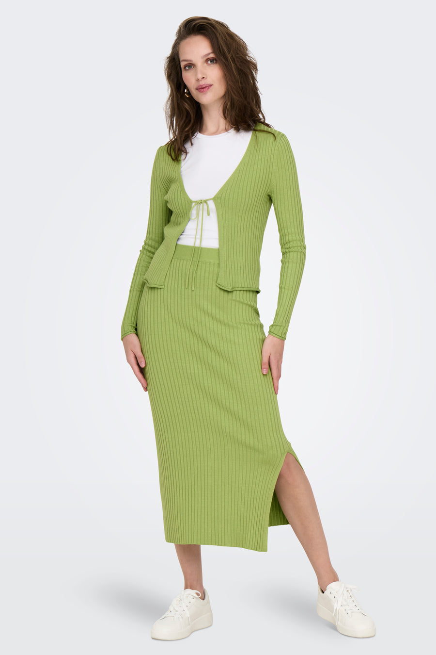 Groene rok van ONLY, met ribbels en een split, gecombineerd met een bijpassend vest en witte sneakers.
