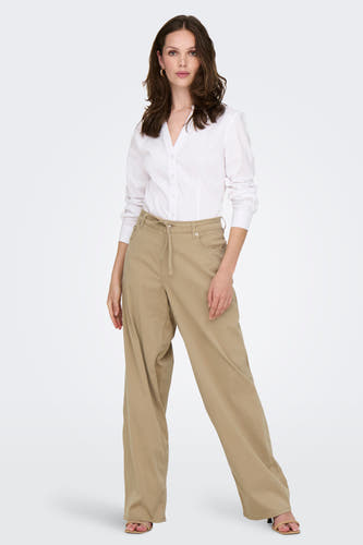 Pantalon beige de ONLY, avec des jambes larges et une ceinture, porté avec un chemisier blanc.
