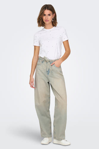 Lichtblauwe wijde jeans van ONLY, met knoopceintuur en gedragen met een wit T-shirt en sneakers.
