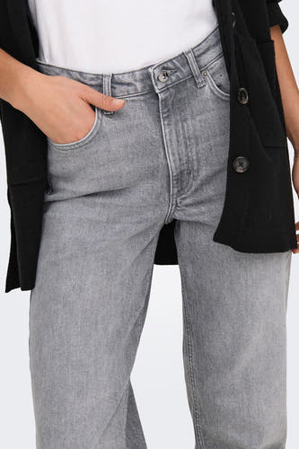 Jean mom gris ONLY, avec la main dans la poche et un cardigan noir.