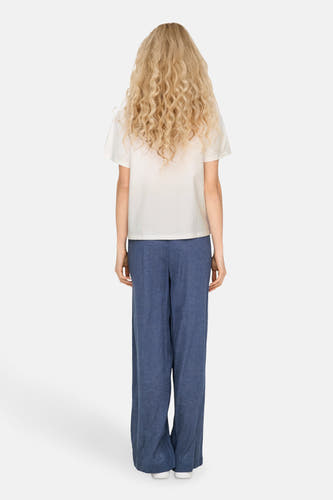 T-shirt blanc à manches courtes de JDY, avec une coupe décontractée et associé à un pantalon de lin bleu.