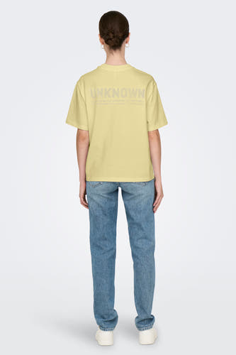 T-shirt jaune à manches courtes de ONLY, avec une impression textuelle sur l'arrière, associé à des jeans.