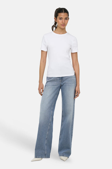 Witte korte mouwen t-shirt van ONLY®, strak model, ronde hals, gedragen met blauwe wijde jeans en witte hakken, front view