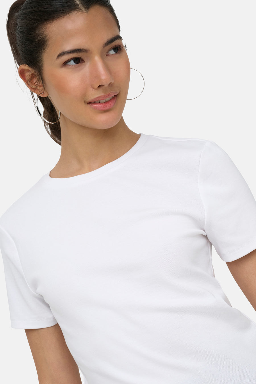 Witte korte mouwen t-shirt van ONLY®, gladde stof, ronde hals, model met grote oorbellen, close-up van bovenkant