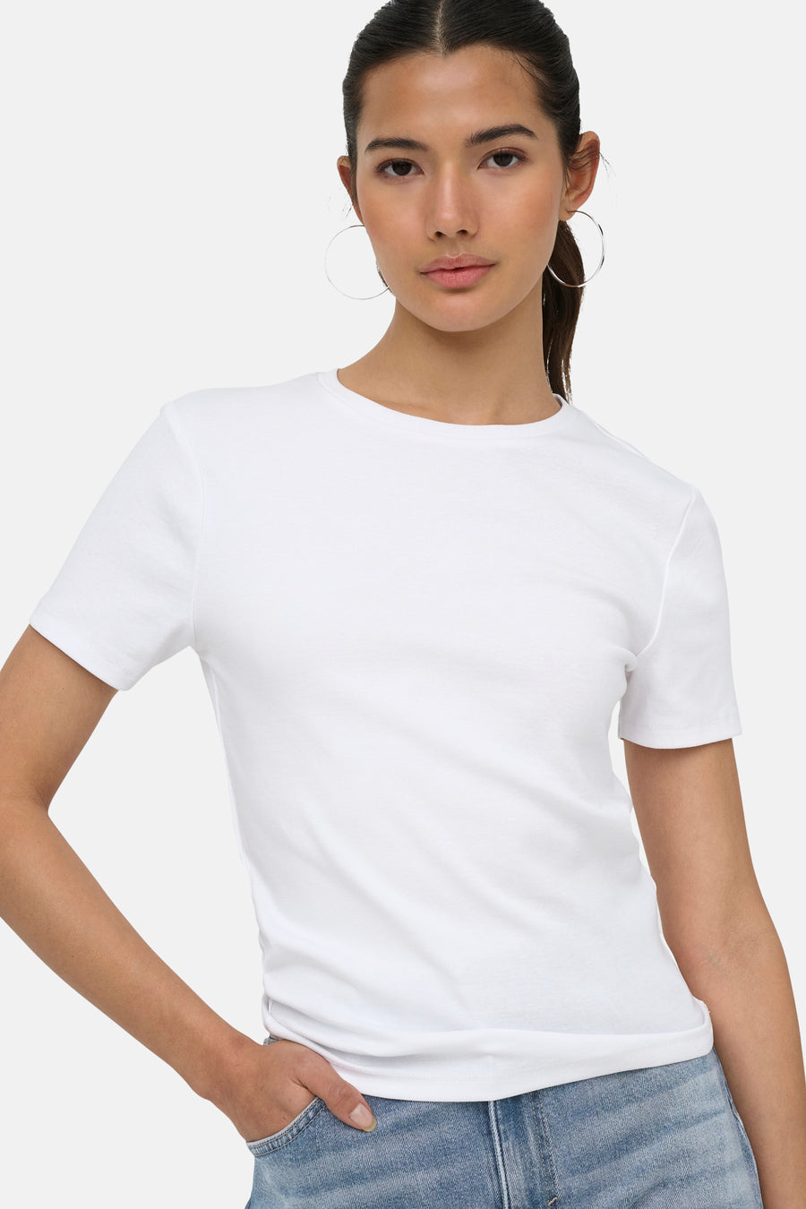 Witte korte mouwen t-shirt van ONLY®, strak model, ronde hals, gedragen met jeans en grote oorbellen, front view