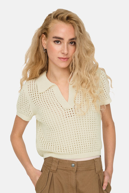 Tunique écru ONLY, avec des manches courtes et une texture ouverte, portée avec un pantalon marron.