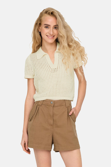 Pull écru de ONLY®, avec une texture ouverte et un col rond, porté avec des short bruns.