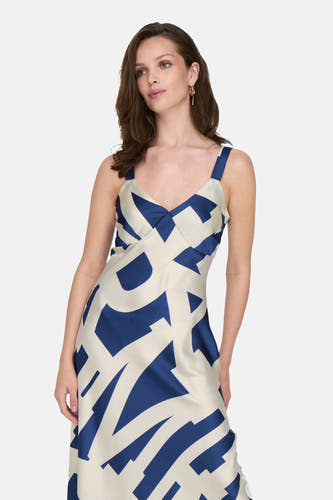 Robe bleue sans manches d'ONLY, avec un motif géométrique blanc et des boucles d'oreilles dorées.