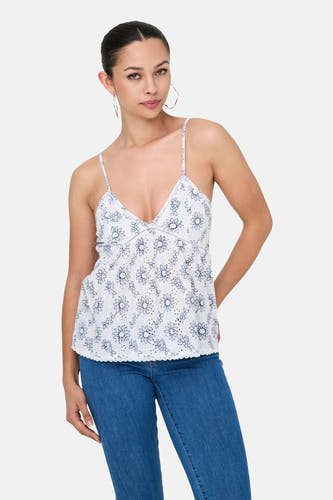 Blouse à manches longues sans col de ONLY®, avec un motif floral, associée à des jeans bleus et des sandales blanches.