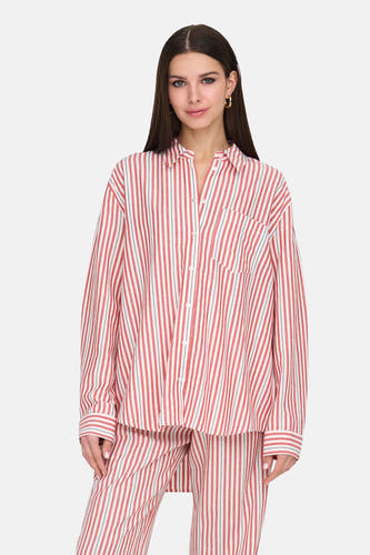 Chemise rayée rouge et blanche à manches longues de ONLY®, portée avec un pantalon rayé assorti et des sandales.
