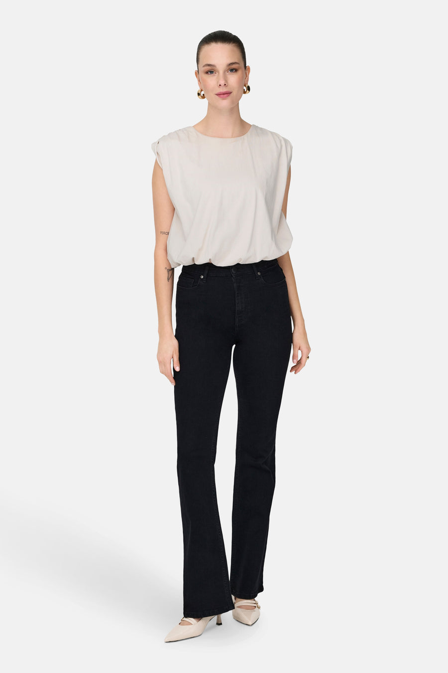 T-shirt sans manches blanc de JDY, avec une encolure arrondie et associé à des jeans noirs et des escarpins.