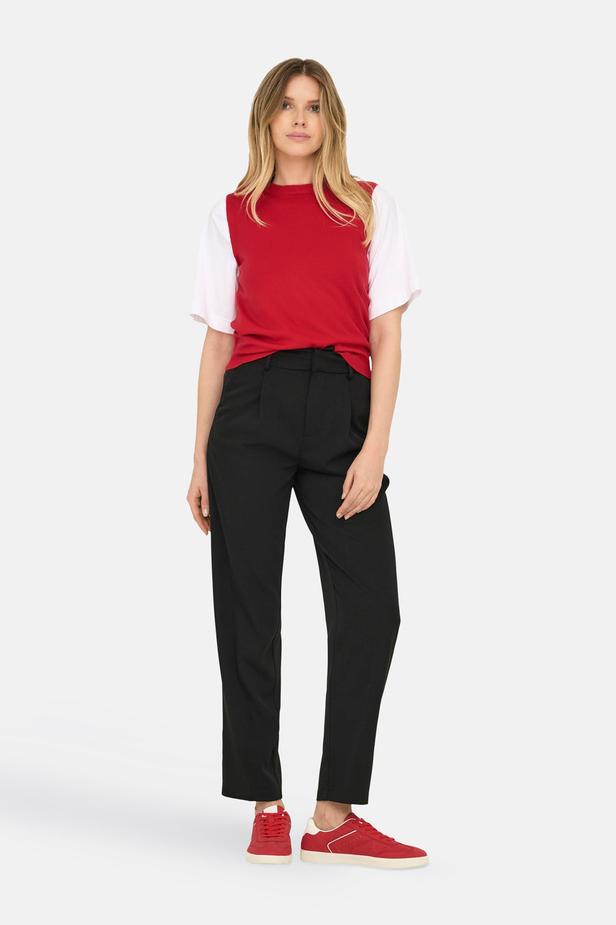 T-shirt rouge de ONLY®, associé à un t-shirt blanc, un pantalon noir et des baskets rouges.