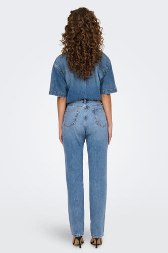 Jean en denim bleu clair de large modèle d'ONLY, avec une taille haute et associé à une blouse en denim.