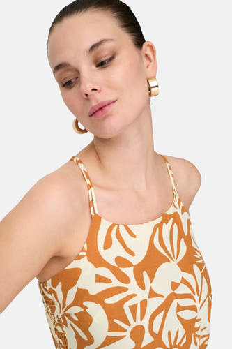 Robe sans manches orange de ONLY, avec un motif de feuilles beige et des boucles d'oreilles dorées.