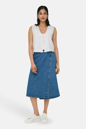 Blouse sans manches blanche de ONLY, avec broderie florale et fermeture éclair à l'avant, associée à une jupe en denim et des baskets blanches.