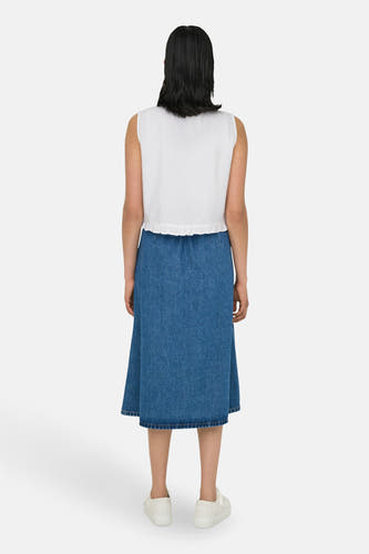 Blouse sans manches blanche de ONLY, avec un bord plié et associée à une jupe en denim et des baskets blanches.