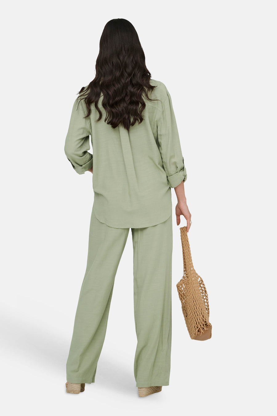 Chemise verte à manches longues de JDY, portée avec un pantalon assorti, vue de dos, avec un sac tissé.
