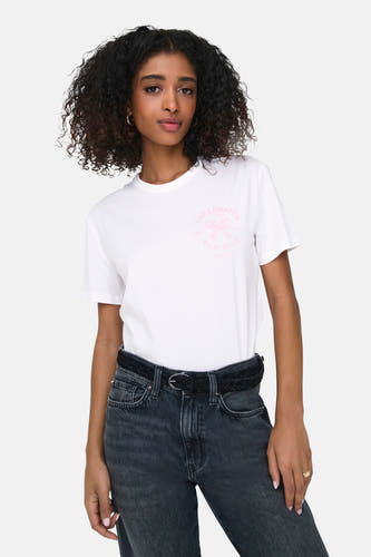 T-shirt blanc à manches courtes d'ONLY, avec une impression rose et porté avec un jean noir et une ceinture.
