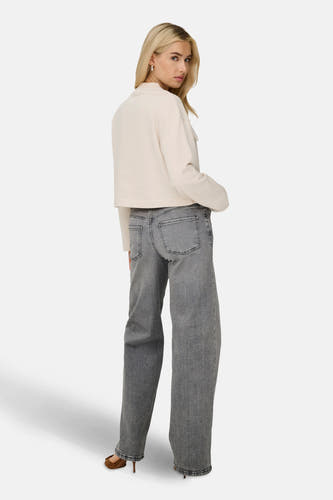 Lichtgrijze, wijde jeans van JDY, met een vintage wassing, gecombineerd met een ecrukleurige trui en bruine pumps.
