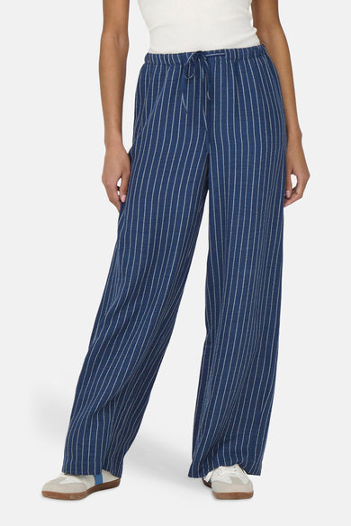 Pantalon bleu de JDY, à rayures craie et cordon de serrage à la taille, porté avec un haut blanc.