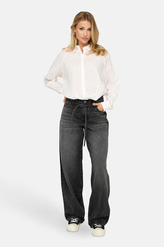 Jean droit gris anthracite de ONLY, porté avec une blouse blanche à des accents argentés et des baskets.
