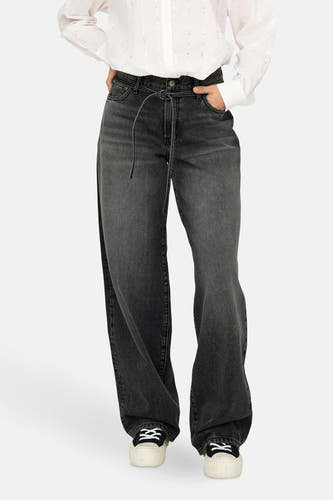 Jean droit gris de ONLY, avec cordon de serrage à la taille, porté avec une blouse blanche et des baskets.