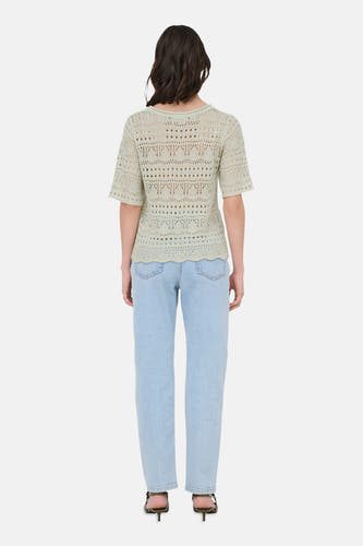 Pull vert avec col rond de JDY, avec motif ajouré et manches courtes, combiné avec un jean bleu clair et des talons.