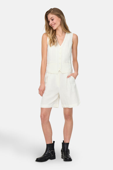 Blazer blanc d'ONLY, porté avec des shorts coordonnés et des bottines noires.