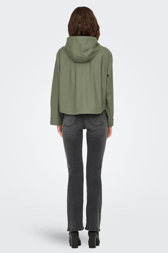 Kaki de pluie ONLY, avec un capuchon, associé à un jean gris et des bottes noires.